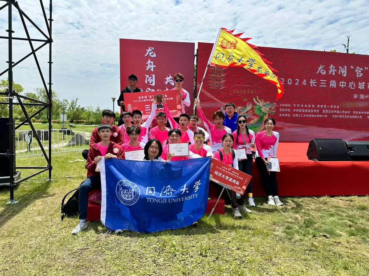 Dragon boat team outdoors with university flag